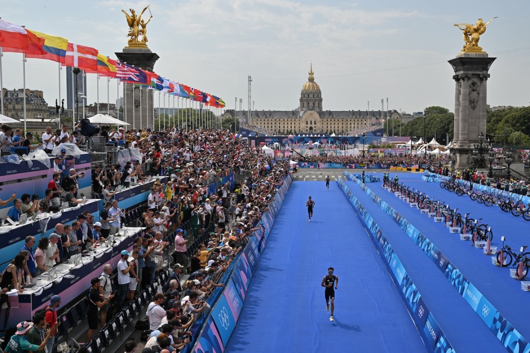 Britain's Alex Yee runs toward the finish line ahead of New Zealand's Hayden Wilde and France's Leo Bergere to win the running stage during the men's individual triathlon at the Paris 2024 Olympic Games in central Paris on July 31, 2024.