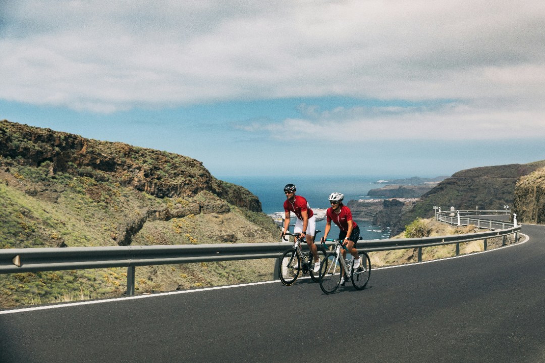 man and woman on bikes on road climb