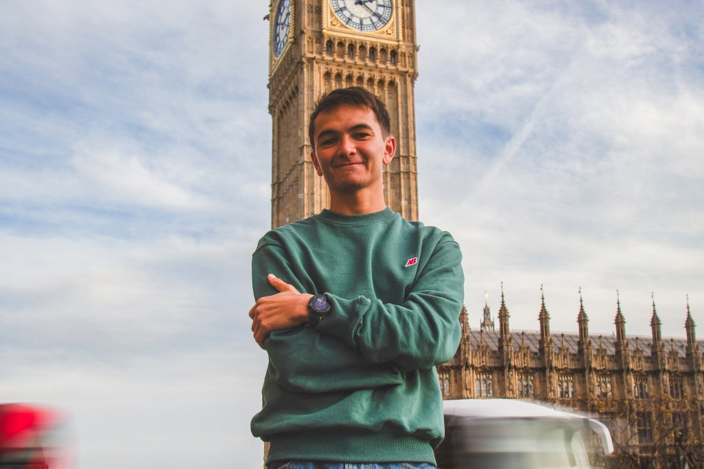 alex yee stands in front of big ben, with arms crossed and a smile