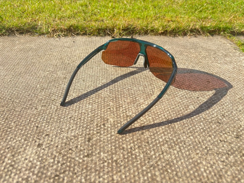 smith motive sunglasses pictured on the ground with angle looking through lens